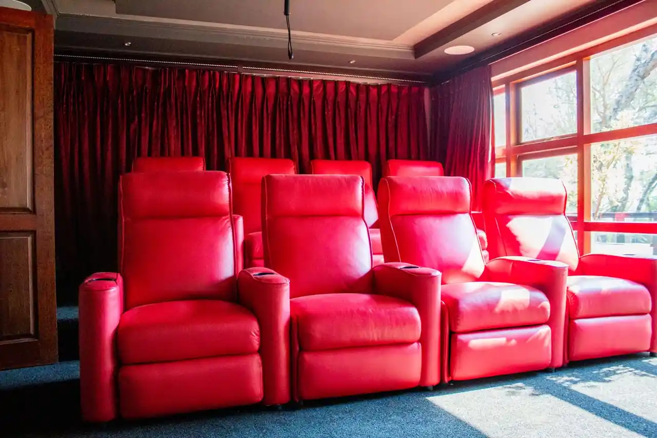 Eleganten ambient zasebnega kina z usnjenimi fotelji v intimni svetlobi